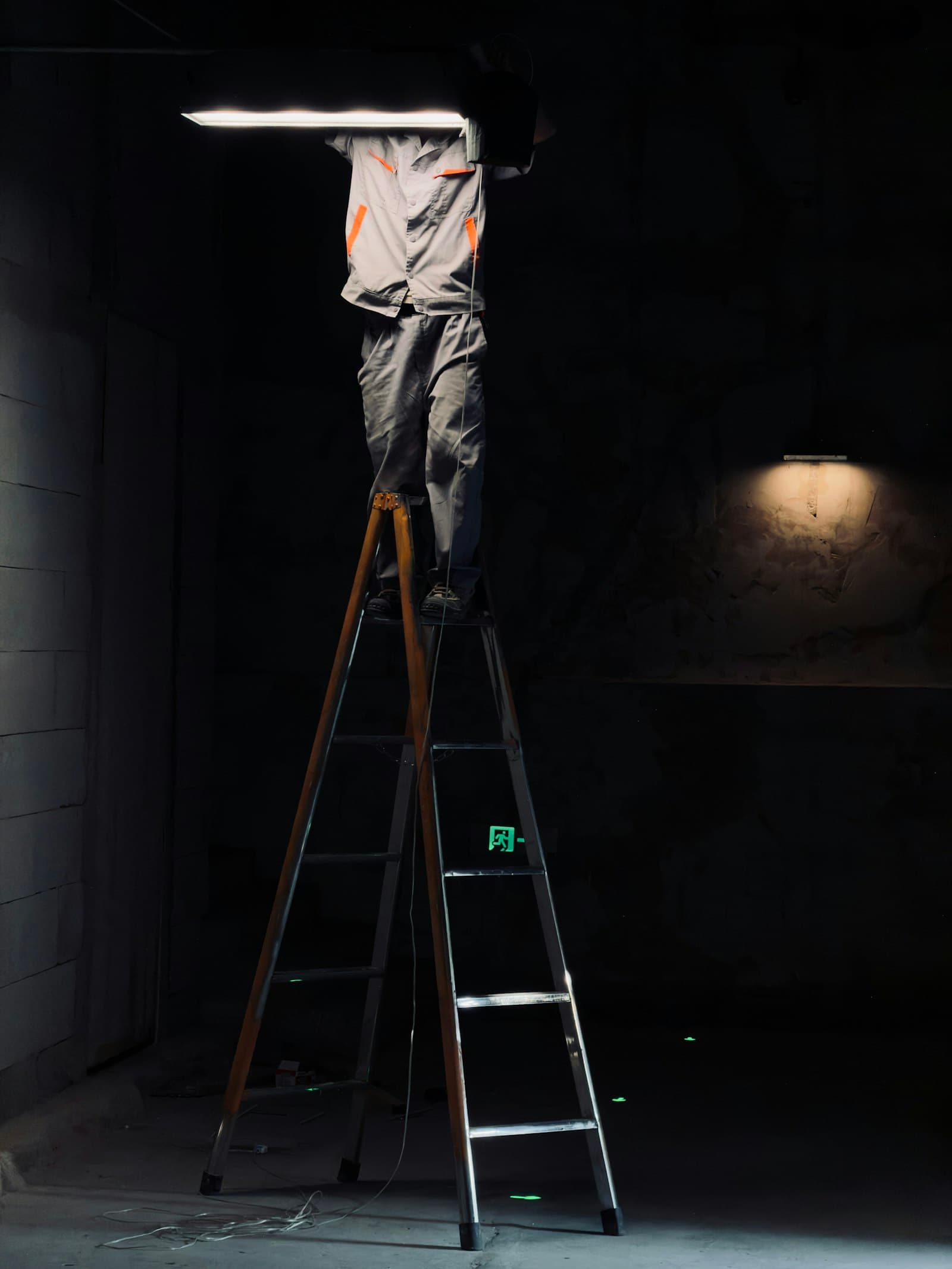 Technician servicing an overhead light fixture